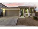 Single-story house with a two-car garage, arched entryway and landscaping at 20442 E Rosa Rd, Queen Creek, AZ 85142