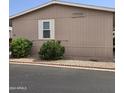 Side view of tan mobile home with shrubbery at 11596 W Sierra Dawn Blvd # 36, Surprise, AZ 85378