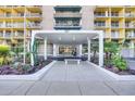 Modern building entrance with landscaping and a bench at 207 W Clarendon Ave # 20B, Phoenix, AZ 85013