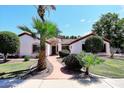 Single-story home with landscaped yard, featuring a terracotta roof and lush greenery at 18997 N 74Th Dr, Glendale, AZ 85308