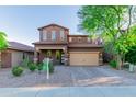 Two-story home with a three-car garage and brick paver driveway at 12687 W Caraveo Pl, Peoria, AZ 85383