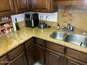 Kitchen features granite countertops, wood cabinets, and a double sink at 5132 N 31St Way # 114, Phoenix, AZ 85016