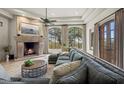 Spacious living room with a cozy fireplace and large windows at 10721 E La Junta Rd, Scottsdale, AZ 85255
