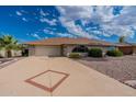 Light gray brick house with a two-car garage and attractive landscaping at 12518 W Skylark Dr, Sun City West, AZ 85375