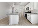 Modern kitchen with granite island and white cabinets at 8330 W Springfield Way, Florence, AZ 85132