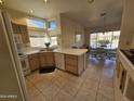 Kitchen with white appliances, wood cabinets, and tile floor at 15406 W Sky Hawk Dr, Sun City West, AZ 85375