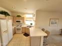 Bright kitchen with white countertops, ample cabinetry, and breakfast bar at 15406 W Sky Hawk Dr, Sun City West, AZ 85375