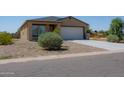 Tan house with a two-car garage and small front yard at 14356 S Vera Cruz Rd, Arizona City, AZ 85123