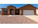 Single-story home with a two-car garage and neutral color palette at 10785 W Arivaca Dr, Arizona City, AZ 85123