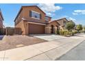 Two-story house with brown exterior, attached garage, and landscaping at 21243 W Coronado Rd, Buckeye, AZ 85396