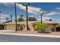 House exterior showcasing brick facade, palm trees, and a courtyard entry at 19434 N 130Th Ave, Sun City West, AZ 85375