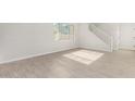 Bright living room with wood-look tile flooring and staircase at 9239 E Spiral Ave, Mesa, AZ 85212