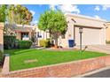 Tan home with a two-car garage and well-maintained lawn at 8638 E Paraiso Dr, Scottsdale, AZ 85255