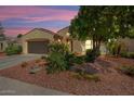 Tan house with brown garage door and landscaping at 22527 N Arrellaga Dr, Sun City West, AZ 85375