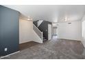 Spacious living room with gray carpeting and stairs at 16716 W Moreland St, Goodyear, AZ 85338