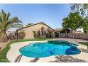 Inviting kidney-shaped pool with a large grassy backyard at 3332 S 256Th Dr, Buckeye, AZ 85326