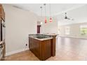Kitchen with a breakfast bar, wood cabinets, granite countertops, and tile flooring at 18112 W Spencer Dr, Surprise, AZ 85374