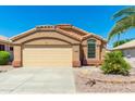 Exterior view of a tan house with a double-car garage and desert landscaping at 18112 W Spencer Dr, Surprise, AZ 85374