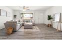 Bright living room featuring L-shaped sofa, large window, and wood-look floors at 12030 N 36Th St, Phoenix, AZ 85028