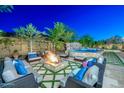 Fire pit and seating area next to a large pool at 12789 W Via Caballo Blanco --, Peoria, AZ 85383