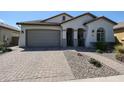 Single-story home with a gray garage door and landscaped front yard at 41301 W Sussex Dr, Maricopa, AZ 85138