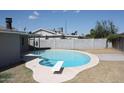 Kidney shaped pool with diving board in backyard at 6604 W Vogel Ave, Glendale, AZ 85302