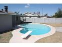 Kidney shaped pool with diving board in backyard at 6604 W Vogel Ave, Glendale, AZ 85302