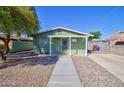 Charming green house with covered porch and driveway at 604 N A St, Eloy, AZ 85131