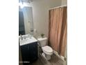 Modern bathroom with dark vanity, updated toilet and shower at 18527 W Caribbean Ln, Surprise, AZ 85388