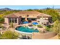 Beautiful backyard with a pool, waterfall, and covered patio at 34617 N Desert Ridge Dr, Scottsdale, AZ 85262