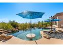 Close-up of negative edge pool with swim-up table and umbrella at 34617 N Desert Ridge Dr, Scottsdale, AZ 85262