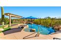 Negative edge pool with a baja step, built in firepit, and artificial turf at 34617 N Desert Ridge Dr, Scottsdale, AZ 85262