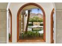 Arch window view of pool, fountain, and mountain backdrop at 6324 N 48Th Pl, Paradise Valley, AZ 85253