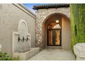 Elegant entryway with stone arch, iron doors, and fountain at 6324 N 48Th Pl, Paradise Valley, AZ 85253