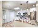 Updated kitchen features a granite island, stainless steel appliances, and white cabinetry at 19202 N Signal Butte Cir, Sun City, AZ 85373