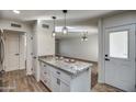 Kitchen with granite island, white cabinets, and access to dining area at 19202 N Signal Butte Cir, Sun City, AZ 85373