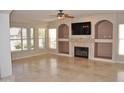 Spacious living room with fireplace, built-in shelves, and tile floors at 11239 E Oberlin Way, Scottsdale, AZ 85262