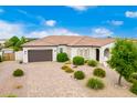Single story home with a brown garage door and landscaped yard at 1312 E Via Sicilia Rd, San Tan Valley, AZ 85140
