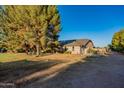 Brick ranch home with a large yard and mature trees at 7601 N Citrus Rd, Waddell, AZ 85355