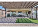 Covered patio with seating area and artificial turf at 35532 N Sunset Trl, San Tan Valley, AZ 85140