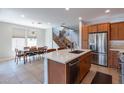 Modern kitchen features a large island with sink, stainless steel appliances, and wood cabinets at 36131 N Desert Tea Dr, Queen Creek, AZ 85140