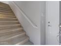 Carpeted staircase with white railing and door at 15240 N 142Nd Ave # 2111, Surprise, AZ 85379
