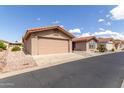 Tan house exterior with a two-car garage and desert landscaping at 3301 S Goldfield Rd # 3004, Apache Junction, AZ 85119