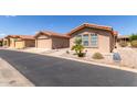 Street view of tan houses with garages and palm trees at 3301 S Goldfield Rd # 3004, Apache Junction, AZ 85119