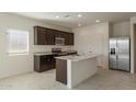 Modern kitchen with dark cabinets, granite countertops, and stainless steel appliances at 24635 W Concorda Dr, Buckeye, AZ 85326