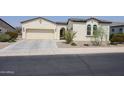 One-story home with tan exterior, two-car garage, and desert landscaping at 17900 W Briarwood Dr, Goodyear, AZ 85338