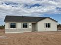 Newly built home featuring a light-colored exterior and dark roof at 31824 N 221St Dr, Wittmann, AZ 85361