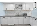 Modern white kitchen with marble backsplash and stainless steel appliances at 5011 S 20Th Pl, Phoenix, AZ 85040