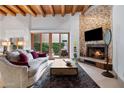 Inviting living room with wood beam ceiling, fireplace, and access to the patio at 6711 E Camelback Rd # 3, Scottsdale, AZ 85251