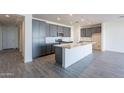 Modern kitchen with gray cabinets, quartz island, and tile floors at 39980 W Bunker Dr, Maricopa, AZ 85138